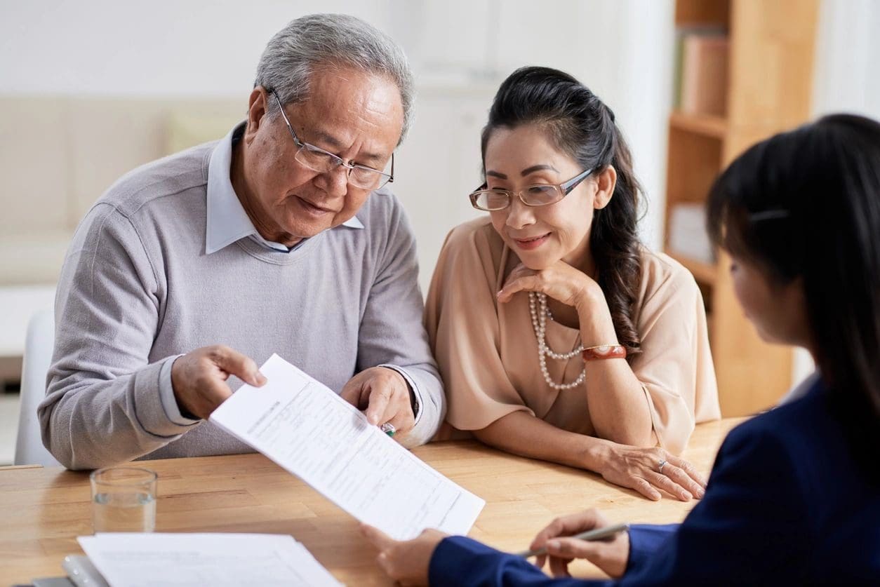 A man and woman looking at papers with an older gentleman.